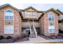 Inviting two-story condo with stone accents and a charming staircase leading to the entrance at 2846 W Centennial Dr # E, Littleton, CO 80123
