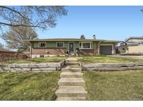 Charming single-story home with a well-manicured lawn and inviting front entrance with beautiful steps at 1465 S Urban Way, Lakewood, CO 80228