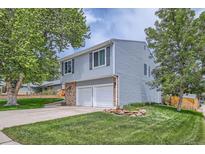 Charming two-story home with a well-maintained lawn, attached two-car garage, and mature trees at 10511 W 101St Ave, Broomfield, CO 80021