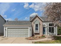 Charming home with a two-car garage, blue door, and a beautiful flower garden at 10275 Quail St, Westminster, CO 80021