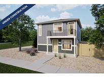 Modern two-story home with gray siding, a small balcony, and low maintenance gravel landscaping at 46517 Avery Ln, Bennett, CO 80102