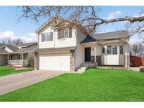 Charming two-story home featuring a two-car garage, manicured lawn, and beautiful stone accents at 5495 Bobcat St, Frederick, CO 80504