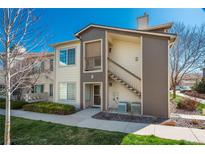 Inviting two-story condo featuring neutral siding, a private entrance, and well-maintained landscaping at 8775 W Berry Ave # 101, Littleton, CO 80123