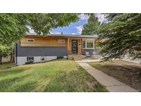 Charming home with a modern exterior, painted brick and light wood, inviting front yard, and a cozy sitting area at 12020 W Alabama Pl, Lakewood, CO 80228