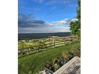 Expansive scenic view from the property overlooking lush greenery, a wooden fence, and a beautiful sky above at 6980 Fargo Trl, Littleton, CO 80125