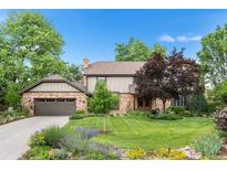 Charming two-story home with brick and siding, mature trees, a well-manicured lawn, and a two-car garage at 5185 W Fair Pl, Littleton, CO 80123