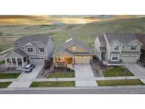 Beautiful suburban homes showcasing manicured lawns and mountain views at sunset at 18922 W 84Th Ave, Arvada, CO 80007