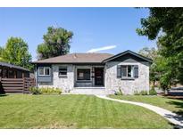 Charming exterior of a ranch-style home with a manicured lawn, whitewashed brick, and updated black trim at 2995 N Cherry St, Denver, CO 80207