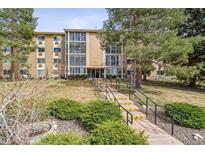 Three-story condo building with glass-enclosed patios and a landscaped lawn at 3022 S Wheeling Way # 407, Aurora, CO 80014