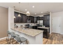 Modern kitchen featuring granite countertops, stainless steel appliances, and dark wood cabinetry at 8183 S Yosemite Ct, Centennial, CO 80112
