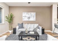 Cozy living room featuring a white sofa, modern art, and stylish decor at 8183 S Yosemite Ct, Centennial, CO 80112