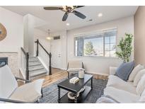 Bright living room with large window, modern furniture, and hardwood floors at 8183 S Yosemite Ct, Centennial, CO 80112