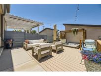 Inviting back deck featuring a pergola, spa, and comfortable seating, perfect for relaxation and outdoor enjoyment at 2235 S Cherokee St, Denver, CO 80223