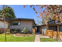 Modern home with wood siding, fresh landscaping, and a walkway leading to the front door at 1485 S Jasmine Way, Denver, CO 80224