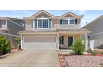 Two-story home with attached two-car garage, neutral siding and green shutters in a residential neighborhood at 19817 E 47Th Pl, Denver, CO 80249