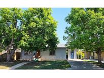 Charming single-story home with a well-maintained lawn and mature trees providing ample shade at 5567 E Asbury Ave, Denver, CO 80222