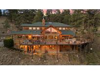 Stunning wooded home featuring a large deck, wood siding, and mountain views at 394 S Ponderosa Way, Evergreen, CO 80439