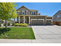 Charming two-story home with a three car garage, manicured lawn, and stone accents at 16188 Elizabeth St, Thornton, CO 80602