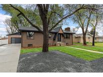 Charming brick home with well-maintained lawn, mature trees, and a modern garage at 4580 Garland St, Wheat Ridge, CO 80033