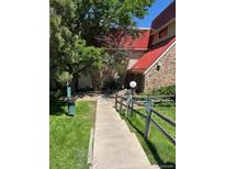 Property exterior with a walkway leading to the entrance and lush green grass at 14751 E Tennessee Dr # 222, Aurora, CO 80012
