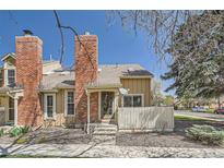Charming two-story home featuring a brick chimney, neutral siding, and a welcoming front entrance with a small fence at 9957 Grove Way # F, Westminster, CO 80031