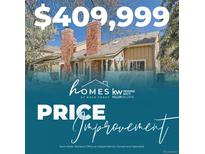 Charming home featuring brick chimney, neutral siding, and a well-maintained front yard with mature trees and a white picket fence at 9957 Grove Way # F, Westminster, CO 80031