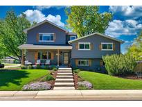 Charming two-story home with gray siding, brick accents, wood shutters, and a beautifully landscaped front yard at 1750 E Noble Pl, Centennial, CO 80121