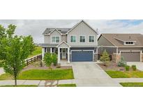 Charming two-story home with a blue garage door and solar panels on the roof at 91 S Quantock St, Aurora, CO 80018
