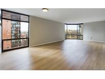 Bright living room featuring hardwood floors, large windows, and city views at 1625 Larimer St # 1001, Denver, CO 80202