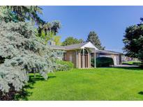 Charming brick home with well-manicured lawn and mature trees, enhancing curb appeal at 3561 Kalispell St, Aurora, CO 80011