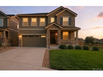 Charming two-story home featuring a covered front porch and a well-maintained lawn at 12554 Hudson Ct, Thornton, CO 80241