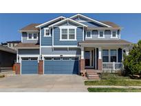 Charming two-story home with a three-car garage and a beautifully landscaped front yard at 18315 W 83Rd Dr, Arvada, CO 80007
