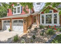 Charming two-story home with a brick entryway, two-car garage, and well-maintained landscaping at 7445 Shoreham Pl, Castle Pines, CO 80108