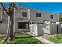 Inviting townhouse featuring a well-maintained lawn, wood siding, and a charming fenced-in front yard at 8745 Yukon St # 30, Arvada, CO 80005