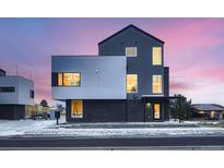 Modern home with geometric design, large windows, and two-tone gray finish under a colorful, bright twilight sky at 10157 W 38Th Ave, Wheat Ridge, CO 80033