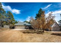 Charming single-story home with attached garage and mature trees under a bright blue sky at 36635 View Ridge Dr, Elizabeth, CO 80107