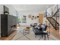 Bright living room features a modern fireplace, hardwood floors, and contemporary furnishings at 1801 W 33Rd Ave, Denver, CO 80211