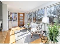 Bright sunroom featuring large windows, wood floors, and stylish furnishings at 4729 W 32Nd Ave, Denver, CO 80212