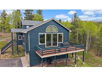 Stunning exterior view features a balcony and large windows overlooking scenic surroundings at 11222 Conifer Mountain Rd, Conifer, CO 80433