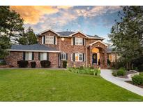Charming two-story brick home with a lush lawn, manicured landscaping, and inviting walkway at 5428 Golden Currant Way, Parker, CO 80134