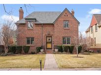 Charming brick two-story home with manicured lawn, slate roof and welcoming front entry at 945 Niagara St, Denver, CO 80220