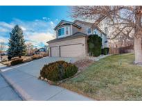 Charming two-story home featuring a two-car garage, landscaped front yard, and inviting curb appeal at 9365 Erminedale Dr, Lone Tree, CO 80124
