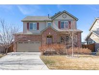 Two-story home featuring brick accents, neutral siding, well-kept landscaping, and an attached two-car garage at 129 N Irvington St, Aurora, CO 80018
