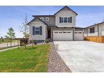 Charming two-story home with three car garage and well-manicured lawn at 9051 Telluride Ct, Commerce City, CO 80022