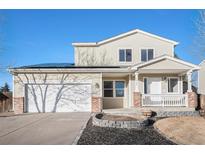 Two-story house with solar panels, attached garage, and landscaped front yard at 1965 E 127Th Cir, Thornton, CO 80241