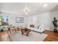 Bright living room with hardwood floors, neutral decor, and stylish furniture; bathed in natural light at 1965 E 127Th Cir, Thornton, CO 80241