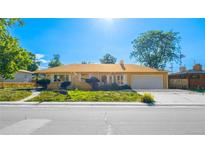 Charming single-story home features a well-kept lawn, mature trees, and attached two-car garage at 1085 Kingston St, Aurora, CO 80010