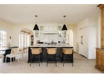 Bright kitchen featuring a large island with bar stool seating and modern pendant lighting at 5700 S Steele St, Greenwood Village, CO 80121
