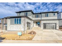 Beautiful new construction home with stone and grey siding, plus two car garage at 8586 Hotchkiss St, Littleton, CO 80125