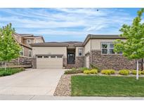 Charming single-Gathering home with stone accents, a manicured lawn, and a two-car garage at 14303 Glenayre Cir, Parker, CO 80134